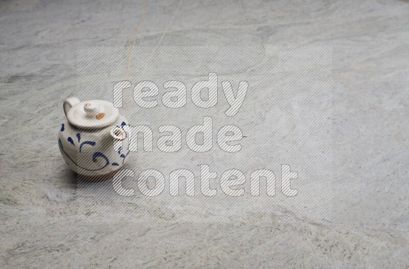 A pottery teapot on grey marble background
