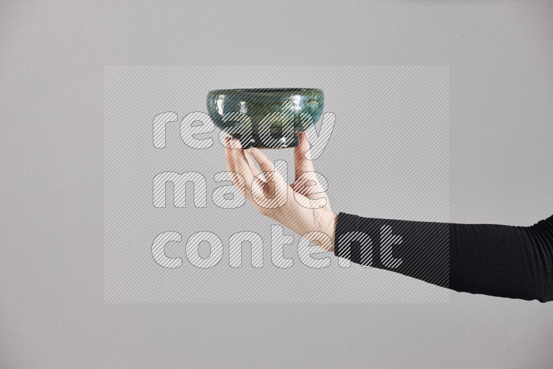 امرأة ترتدي عباءة سوداء تحمل أدوات فخارية مختلفة في أوضاع متعددة