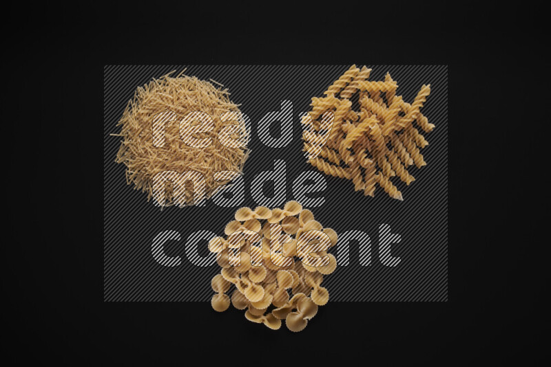 Different pasta types in bunches on black background