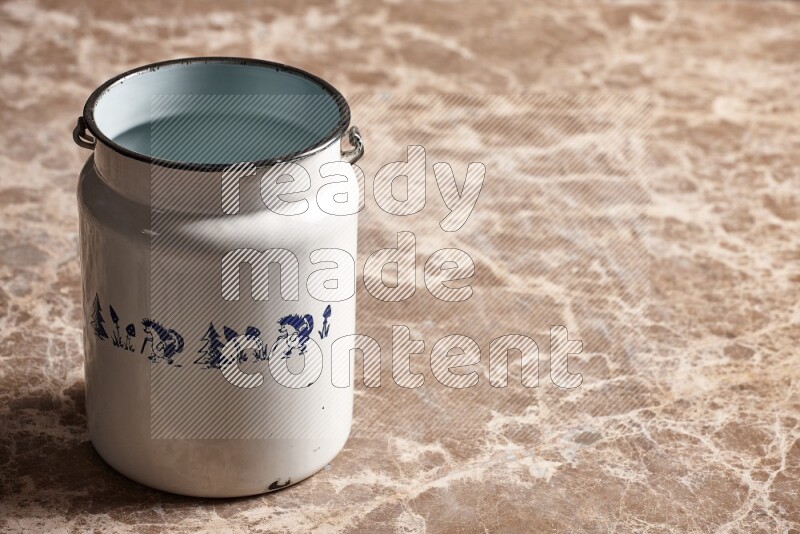 A vintage milk can on beige marble background