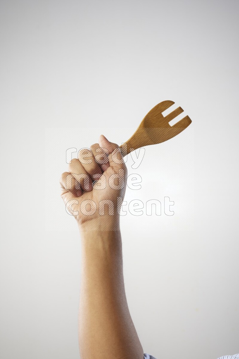 Male Hand Holding Wooden Fork on white  background