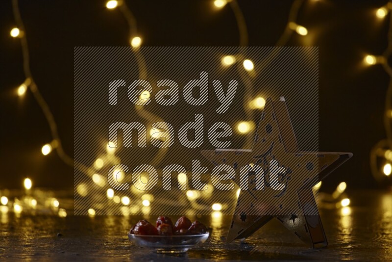 A traditional ramadan lantern surrounded by glowing fairy lights in a dark setup