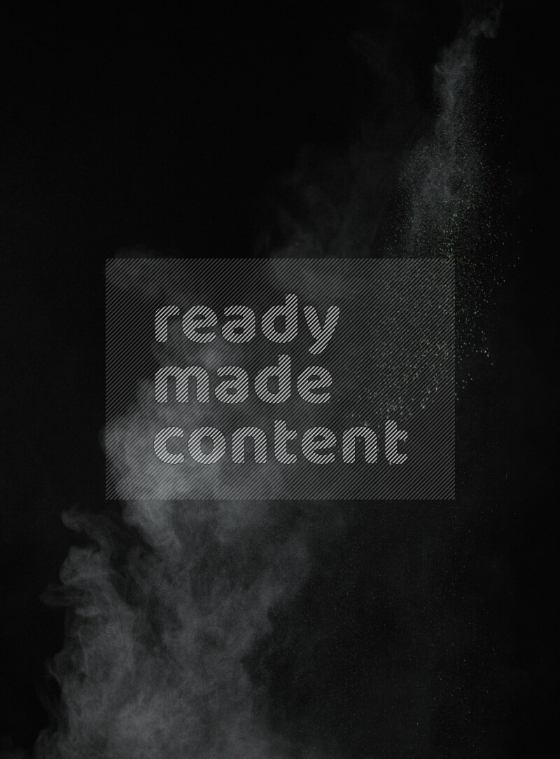 A side view of green powder explosion on black background