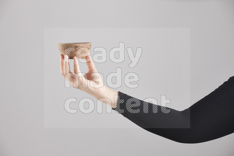 امرأة ترتدي عباءة سوداء تحمل أدوات خشبية مختلفة في أوضاع متعددة