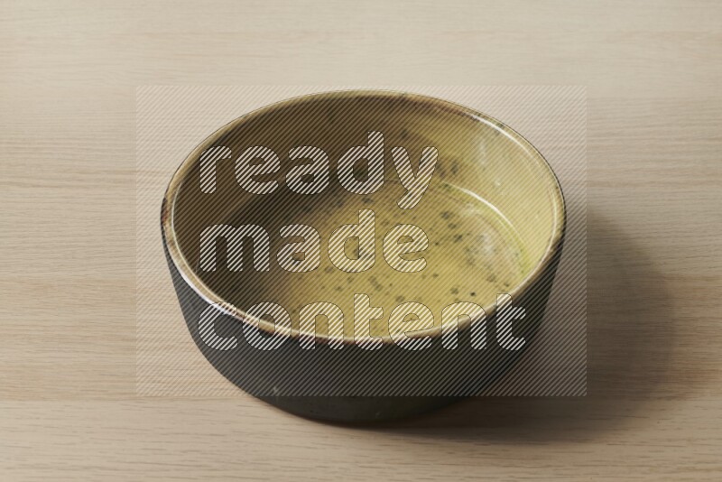A multicolored pottery oven plate on light wooden background