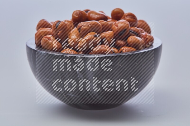 Close up shot of cooked fava beans (foul) in a container on white background