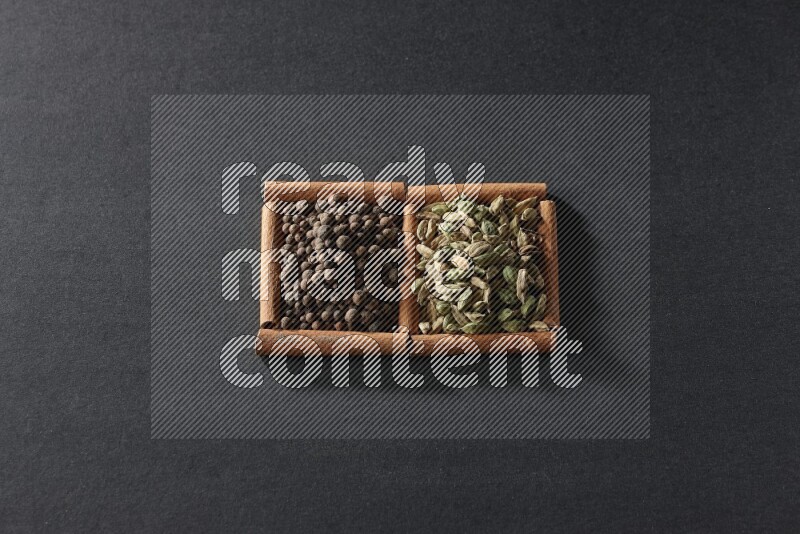 2 squares of cinnamon sticks full of allspice and cardamom on black flooring