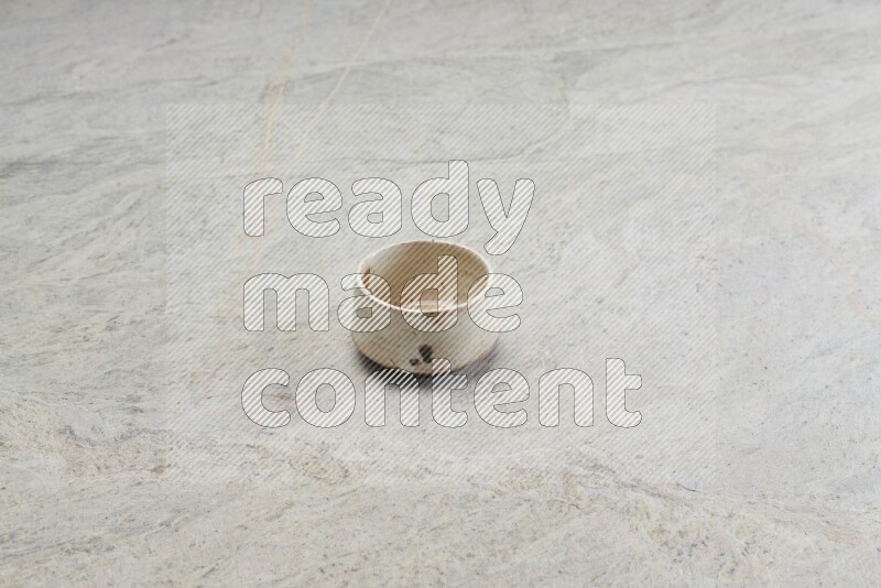 A multicolored pottery bowl on grey marble background