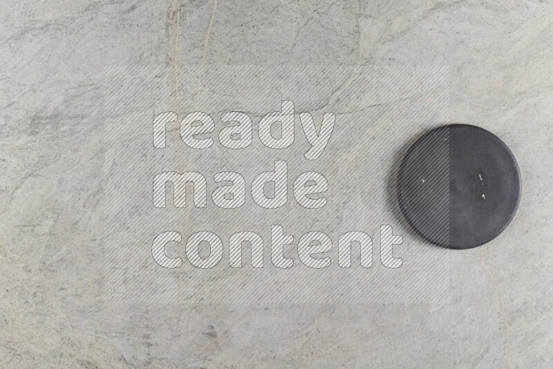 A pottery coaster on grey marble background