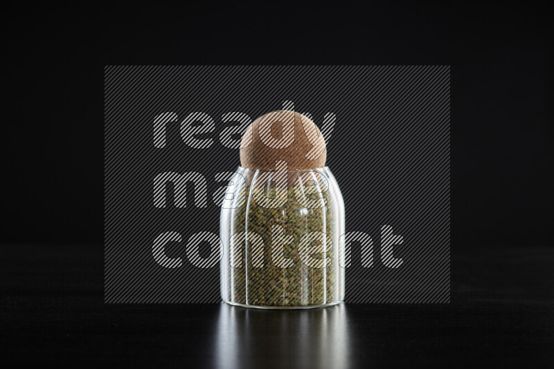 Freekeh in a glass jar on black background