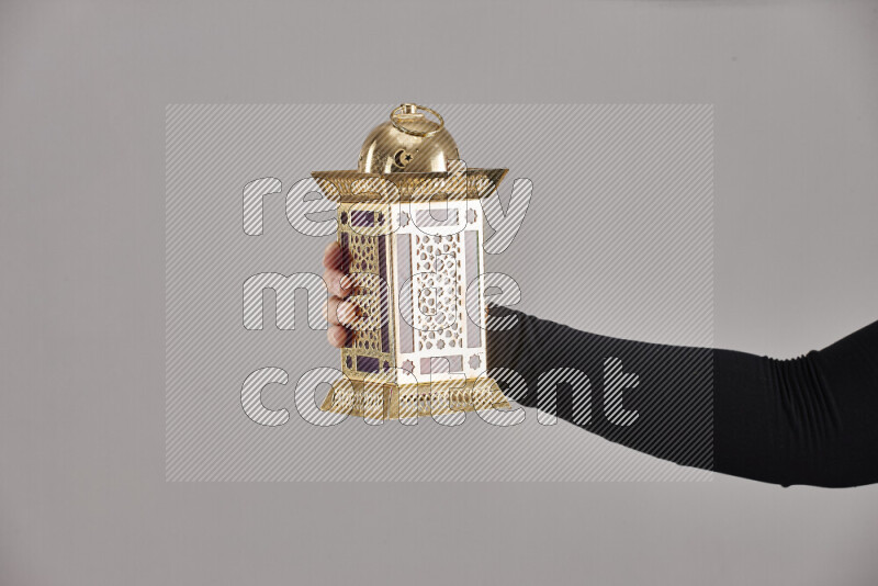 A woman in black abaya holding different ramadan lanterns in different positions