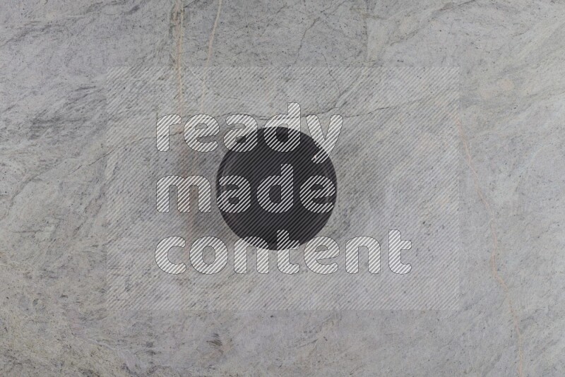 A black pottery bowl on grey marble background