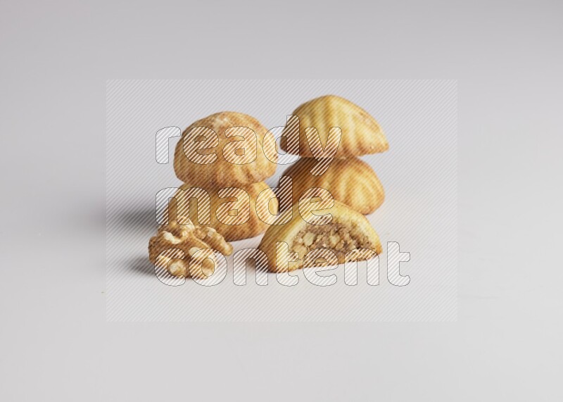 Five Pieces of Maamoul filled with walnut paste  one of them is cut with direct on white background