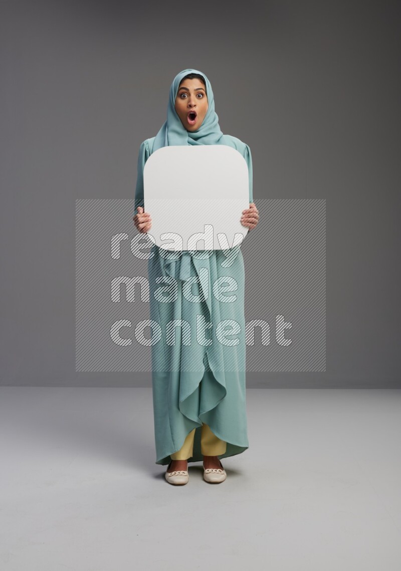 Saudi Woman wearing Abaya standing holding social media sign on Gray background