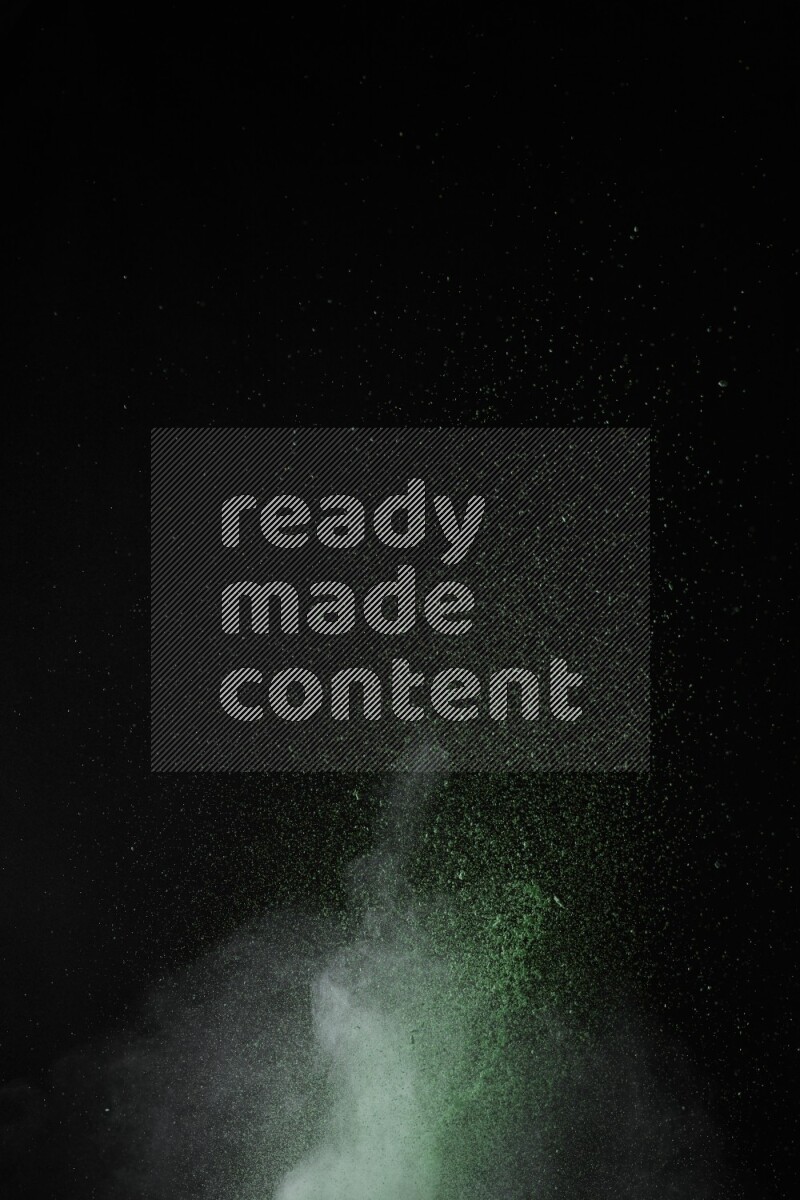 A side view of green powder explosion on black background