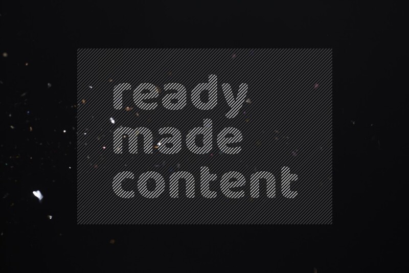 Falling multicolored confetti on black background