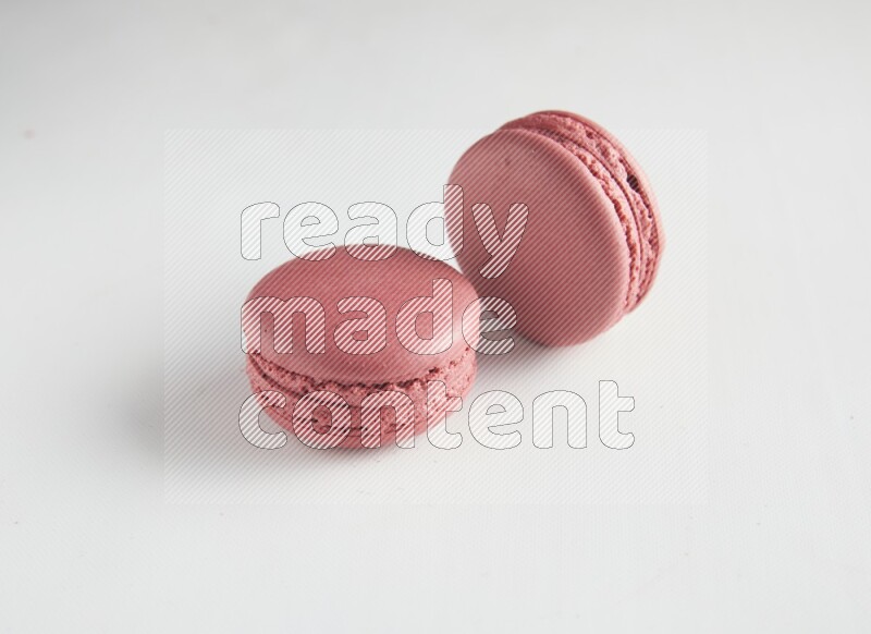 45º Shot of two Pink Raspberry macarons on white background