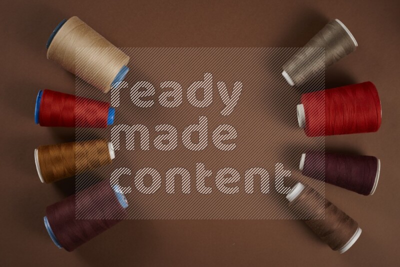 A red collection of sewing and tailoring tools arranged on a brown background