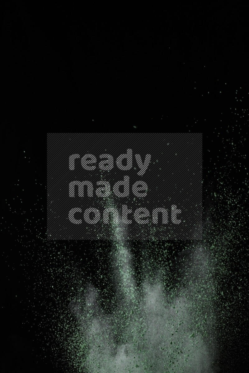 A side view of green powder explosion on black background