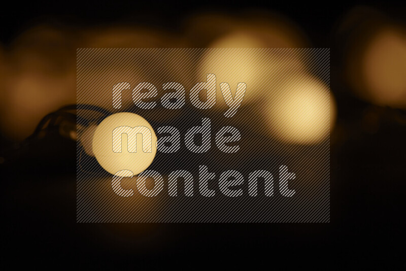 Light bulbs glowing against backdrop of golden bokeh