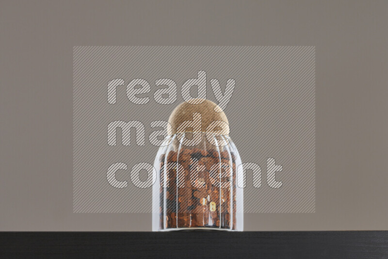 Sequins in a glass jar on black background