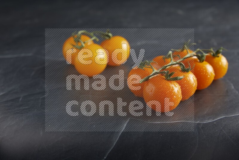 Mixed cherry tomato veins on a textured black slate background 45 degree