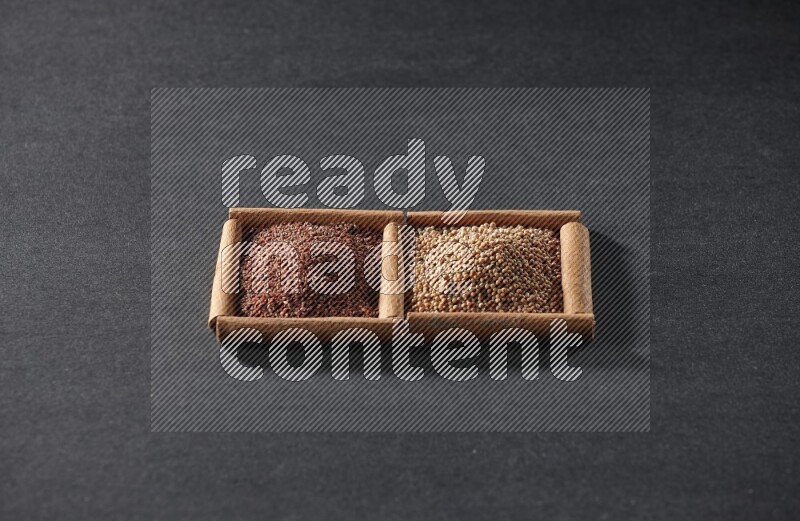 مربعان من أعواد القرفة ممتلئان بحبوب الخردل وحب الرشاد علي خلفية سوداء