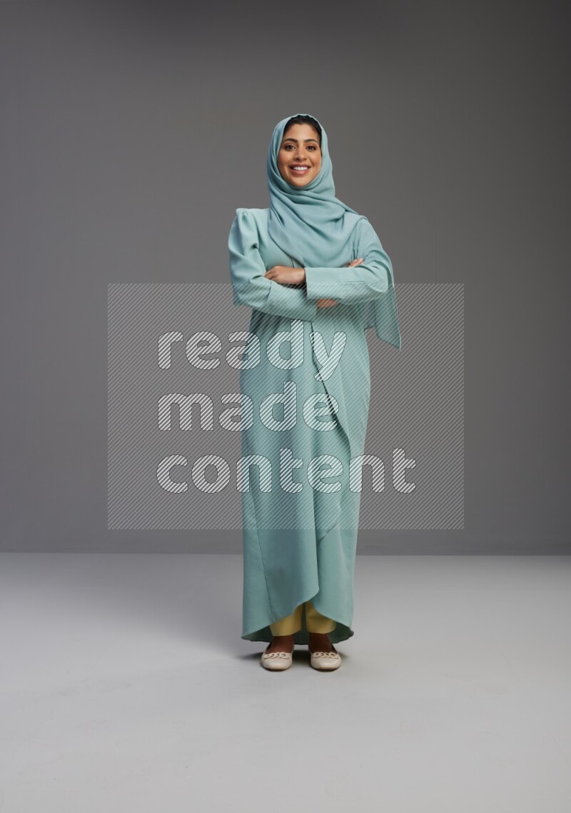 Saudi Woman wearing Abaya standing with crossed arms on Gray background