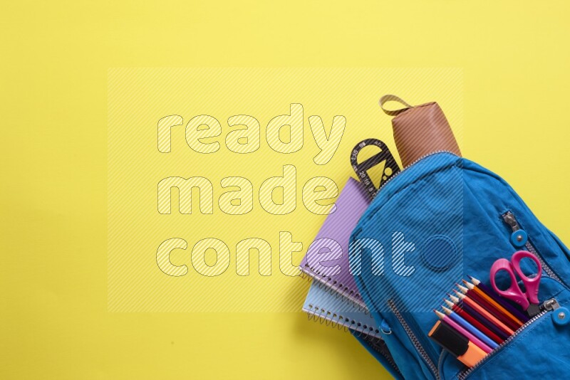 A blue school bag placed on yellow background