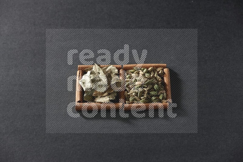 2 squares of cinnamon sticks full of cardamom and bay laurel leaves on black flooring