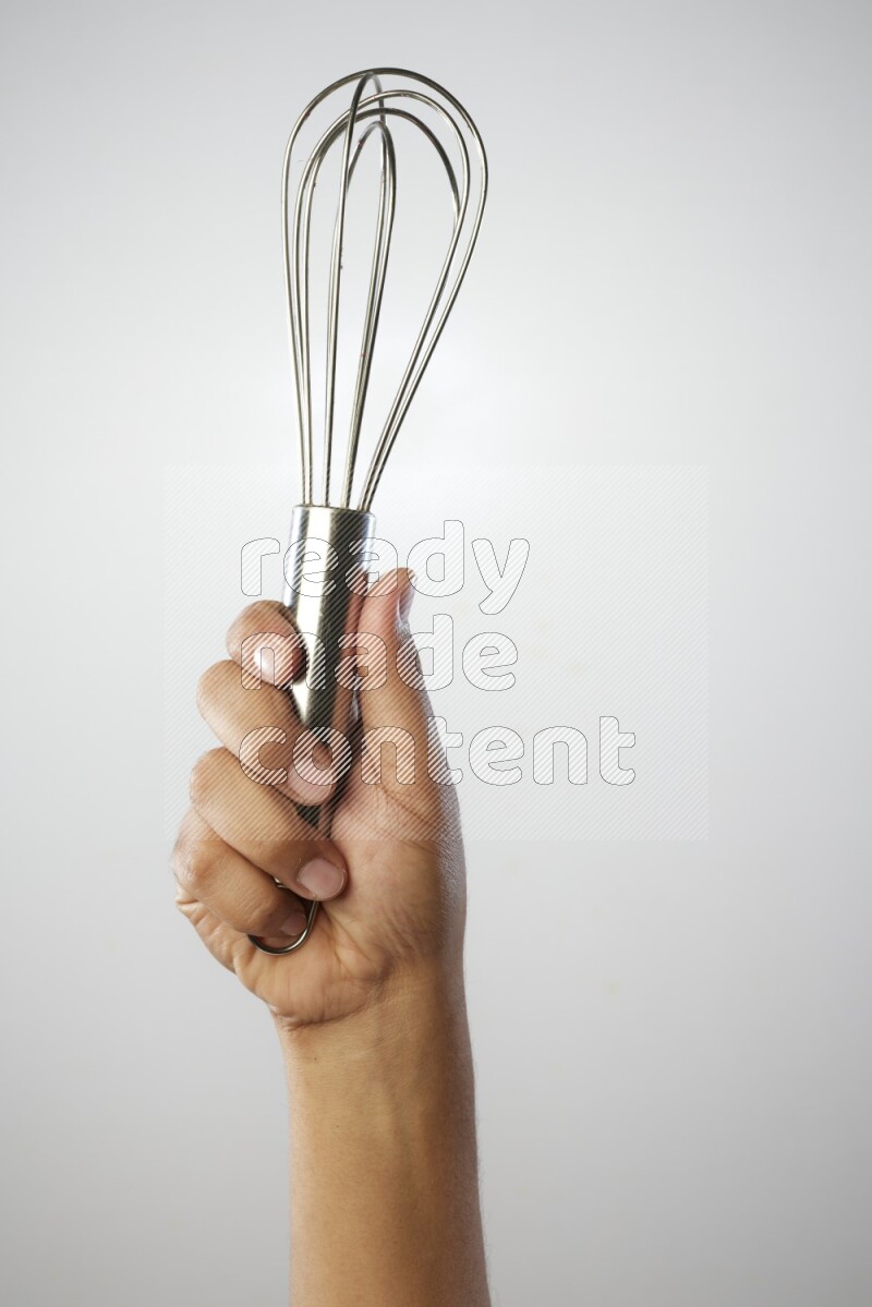 Male Hand Holding Whisk on white background