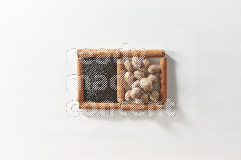 2 squares of cinnamon sticks full of black seeds and nutmeg on white flooring