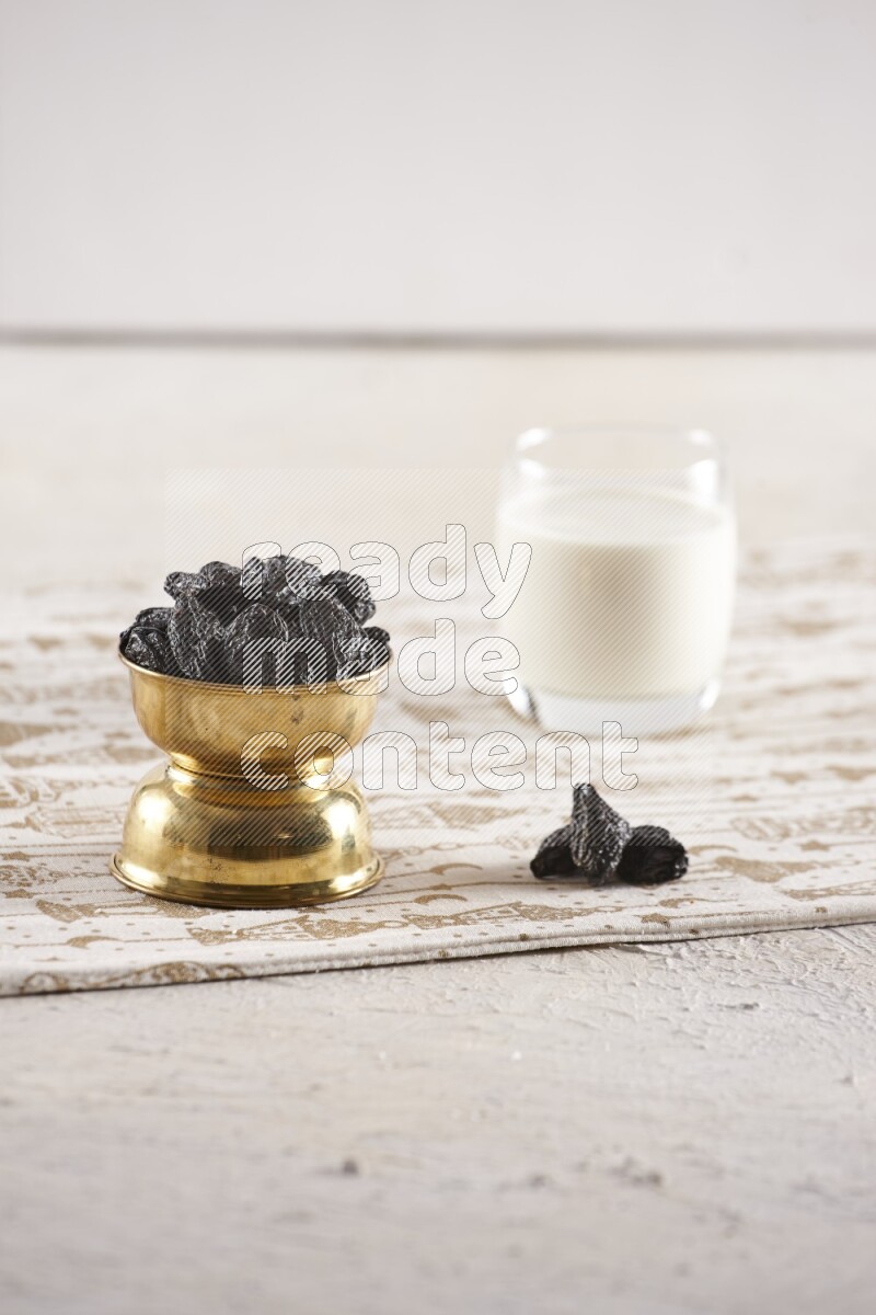 Dried fruits in a metal bowl with milk in a light setup