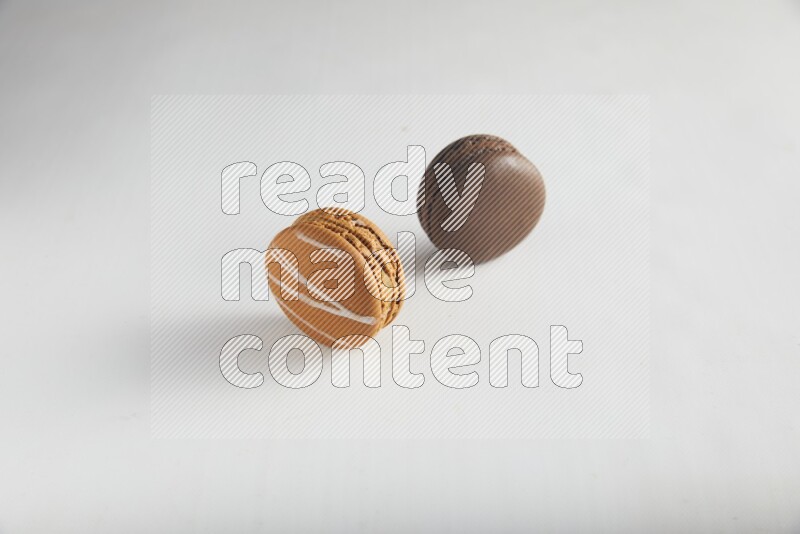 45º Shot of of two assorted Brown Irish Cream, and Brown Dark Chocolate macarons on white background