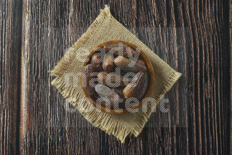 Dates in different bowls (wooden, pottery and glass) on wooden background