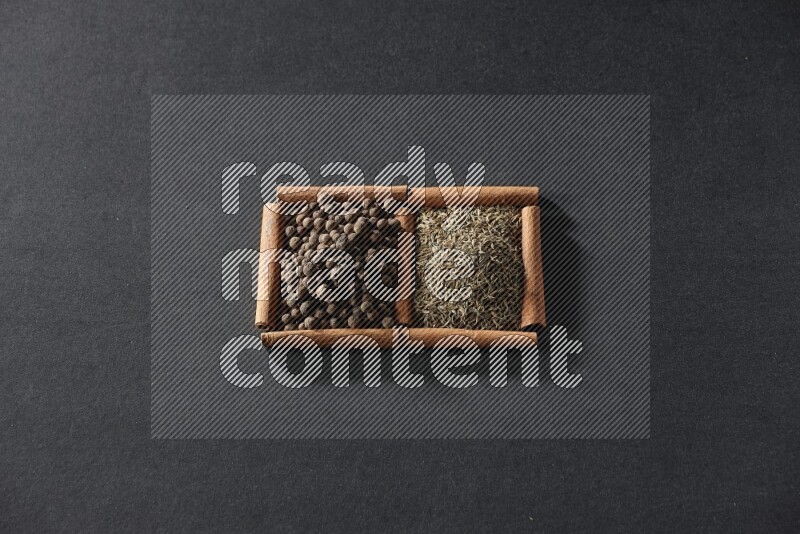 2 squares of cinnamon sticks full of cumin and allspice on black flooring