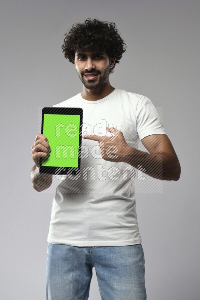 A man wearing casual standing and showing a tablet screen on white background