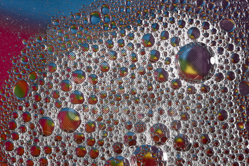 Close-ups of abstract soap bubbles and water droplets on multicolored background