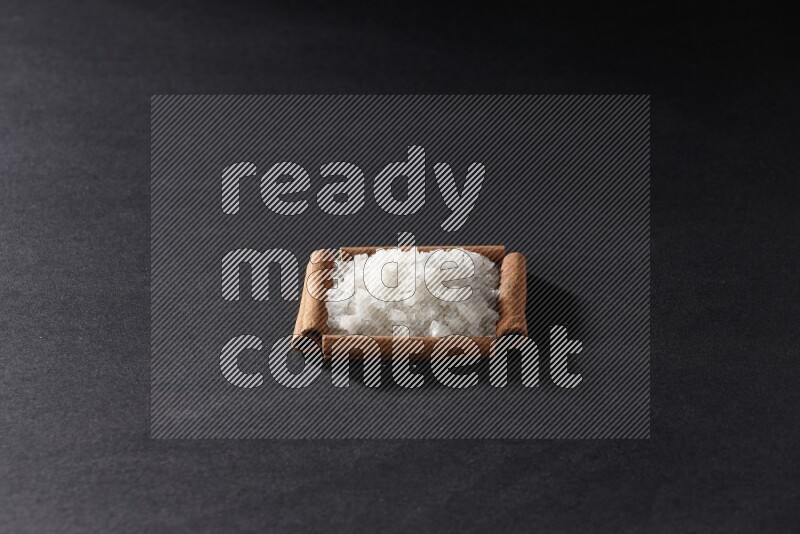 A single square of cinnamon sticks full of salt on black flooring