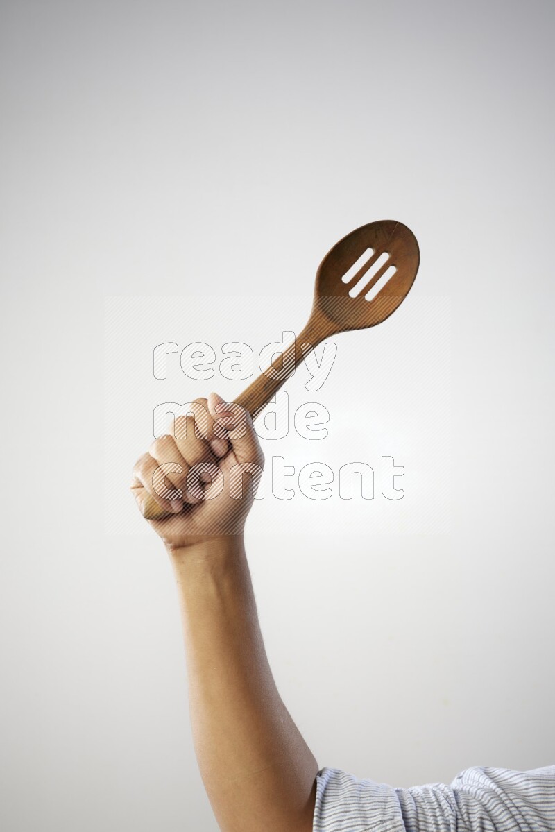 Male Hand Holding Wooden colander spoon  on white background