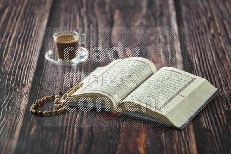 Quran with dates, prayer beads and different drinks all placed on wooden background
