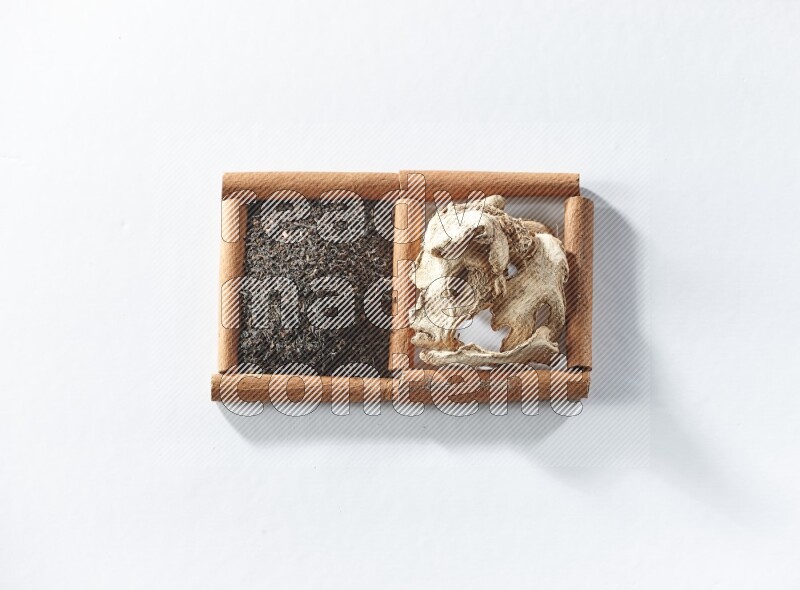 2 squares of cinnamon sticks full of black tea and dried ginger on white flooring