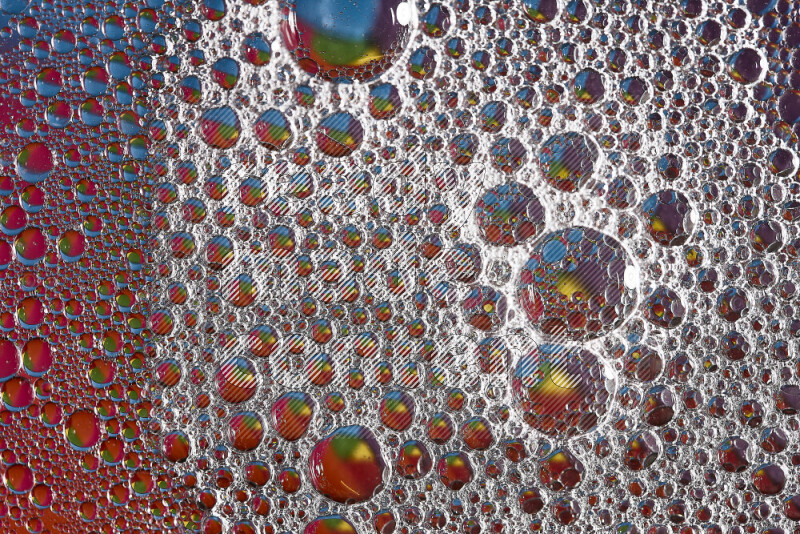 Close-ups of abstract soap bubbles and water droplets on multicolored background