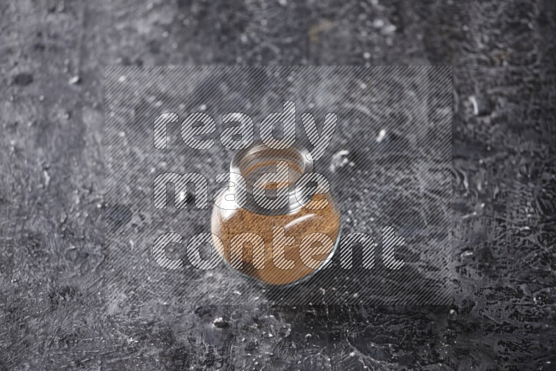 قرفة في وعاء زجاجي علي خلفية سوداء