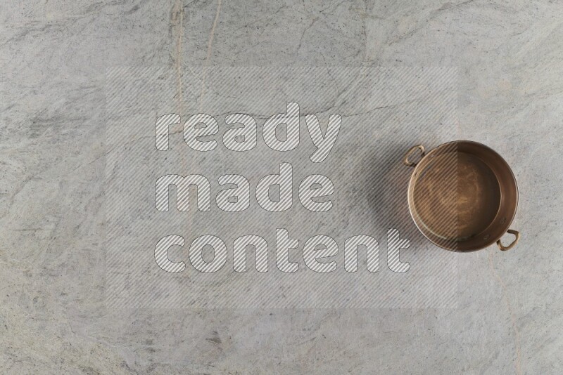 A small copper pan on grey marble background