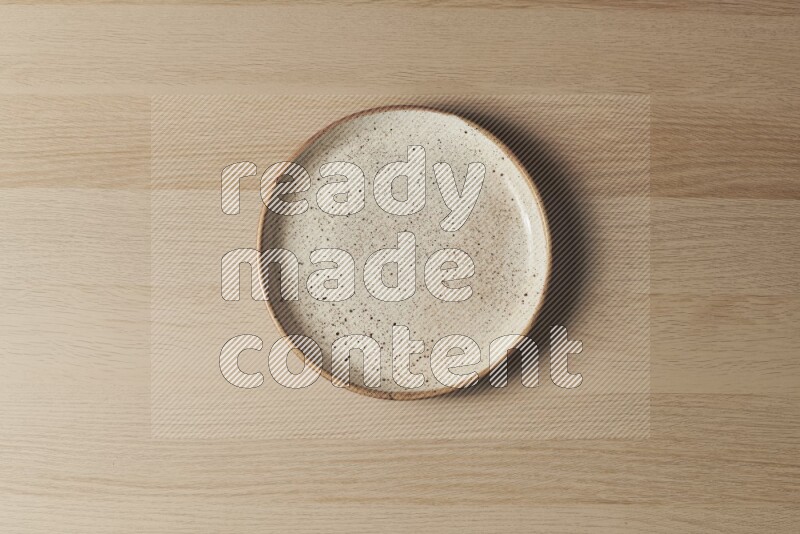 A multicolored pottery plate on light wooden background