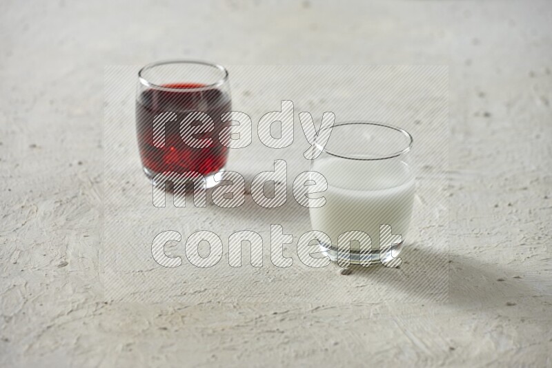 Cold drinks in a glass cup such as water, tamarind, qamar eldin, sobia, milk and hibiscus on textured white background