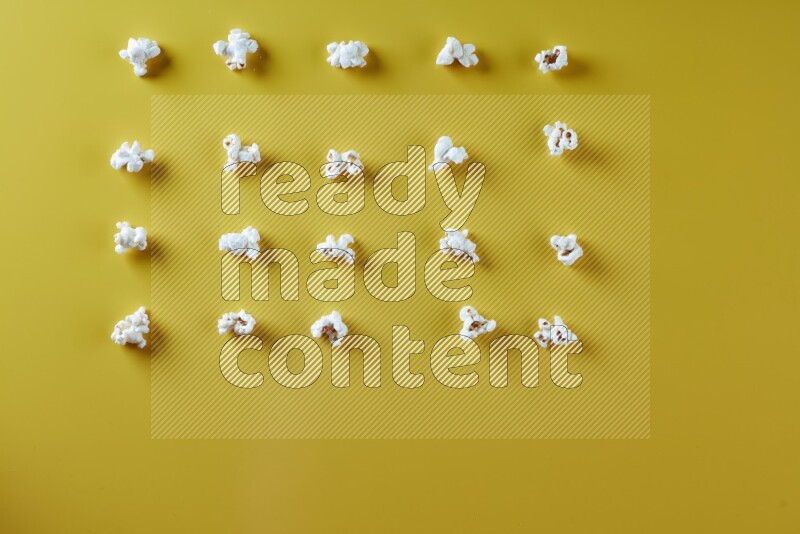 Popcorn flakes on a yellow background in different angles