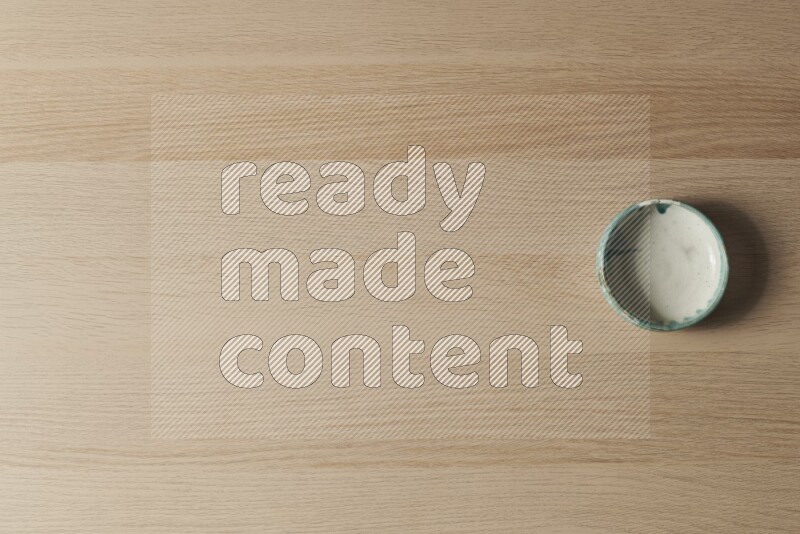 A multicolored pottery bowl on light wooden background