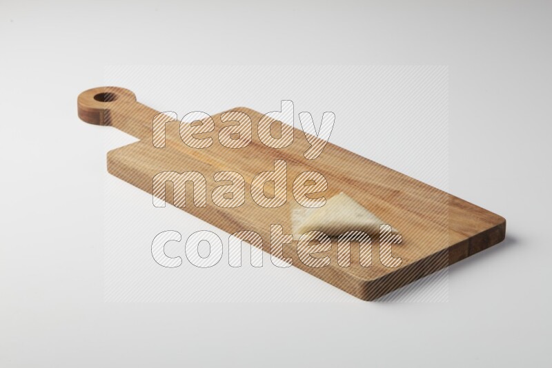 One uncooked samosa on a wooden cutter on a white background